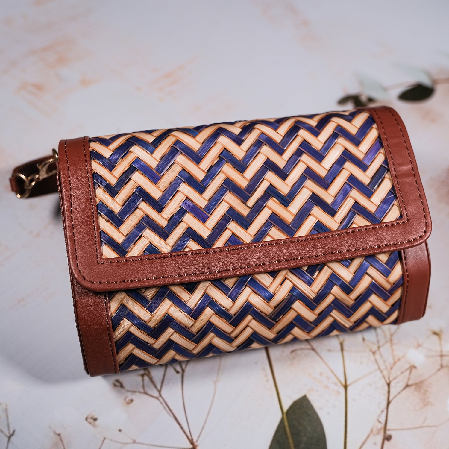 Woven clutch bag with blue and beige pattern on a light background