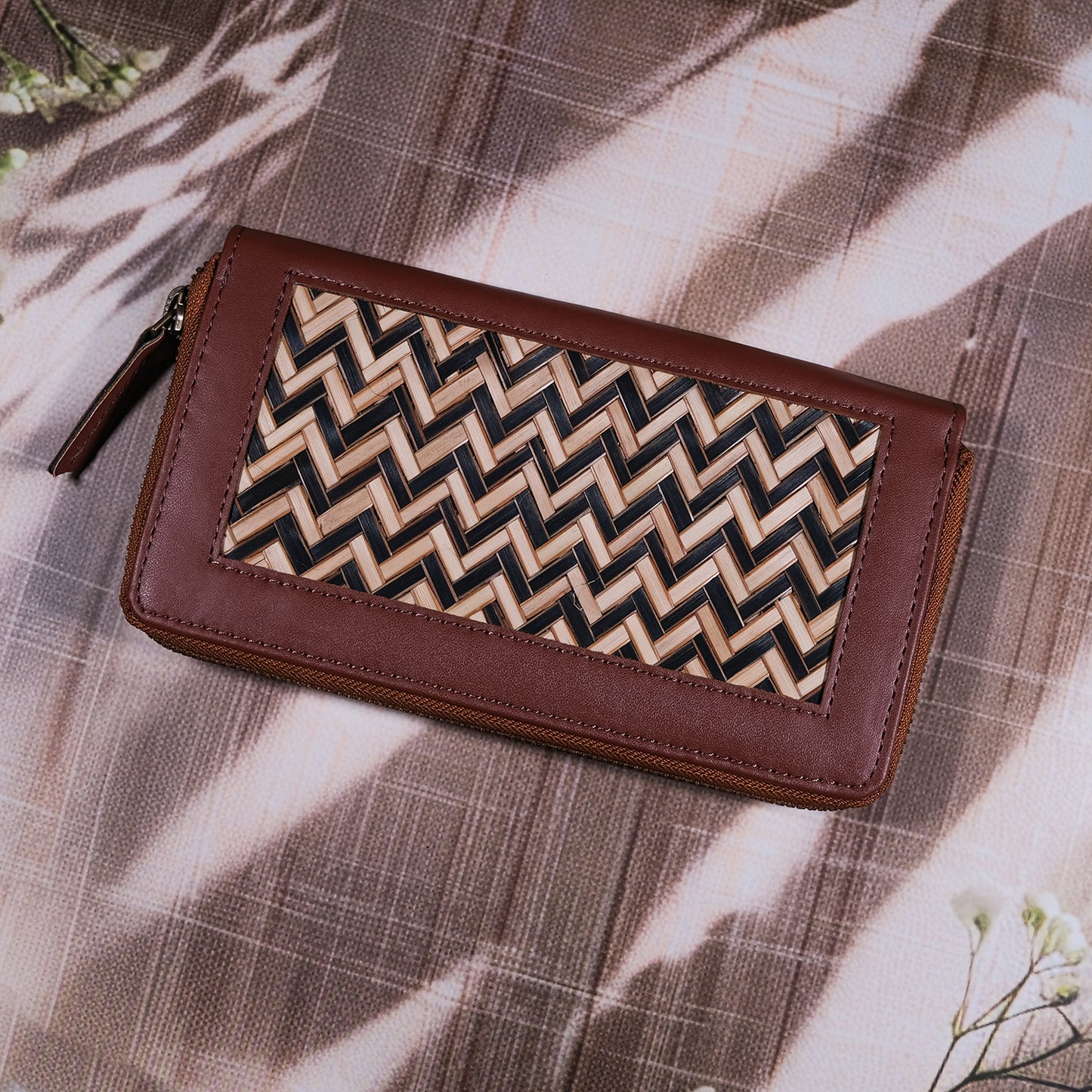 Brown wallet with a zigzag pattern on a textured surface