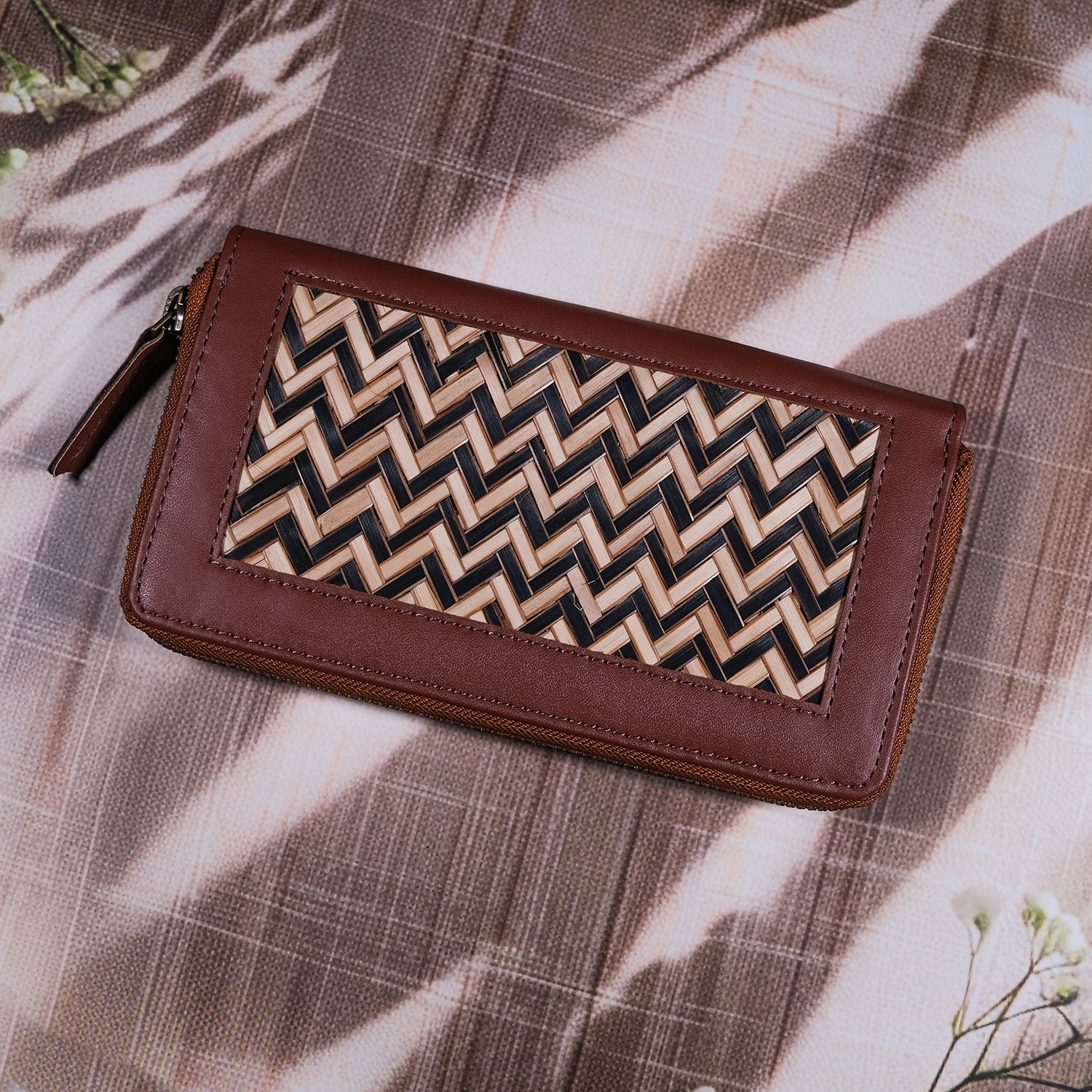 Brown wallet with a zigzag pattern on a textured surface